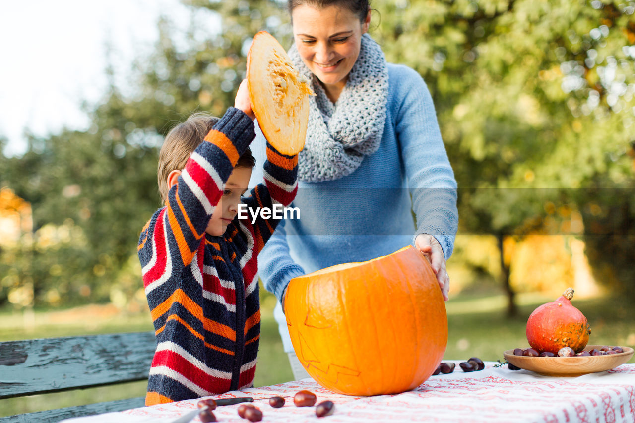 Mother and son with pumpkin in garden