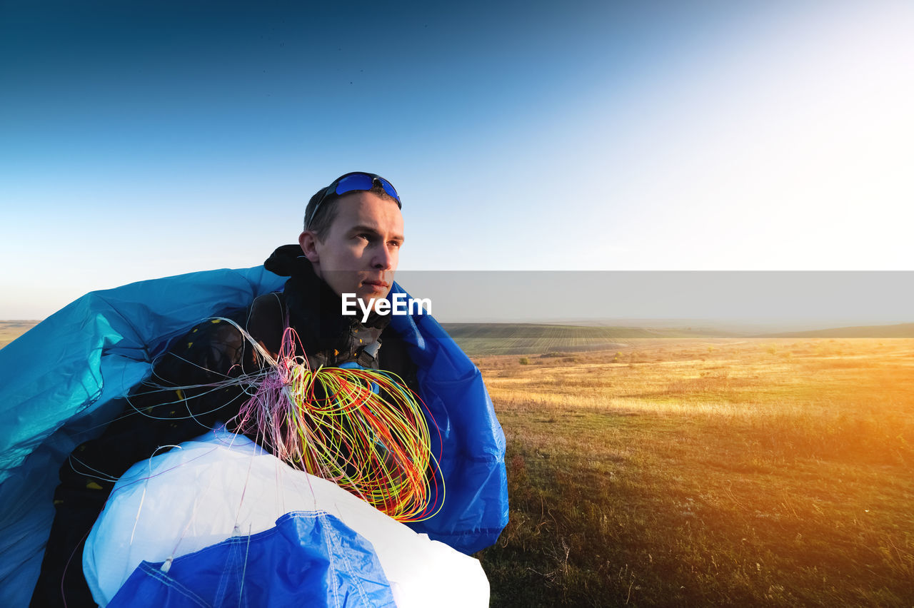 Guy holds the lines of a paraglider in his hands close-up. a male paraglider carries a paraglider to