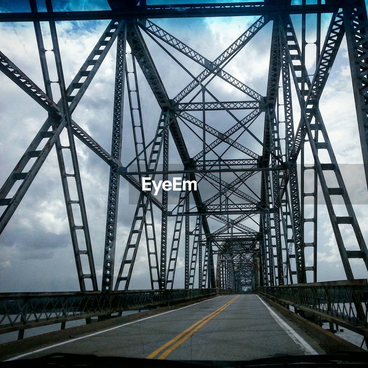 Bridge over sea against cloudy sky