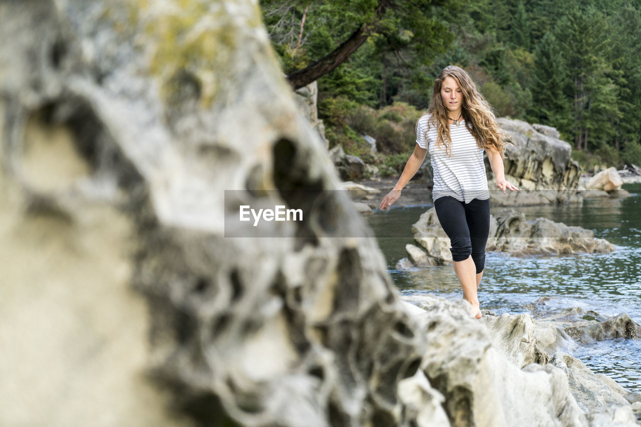 Teenage girl walking along rocky shore near clayton beach, wa