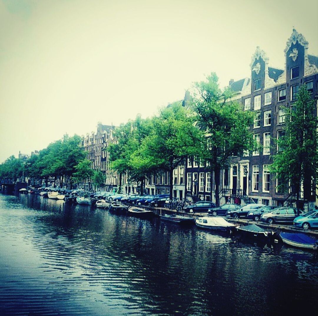 Boats moored on canal by city