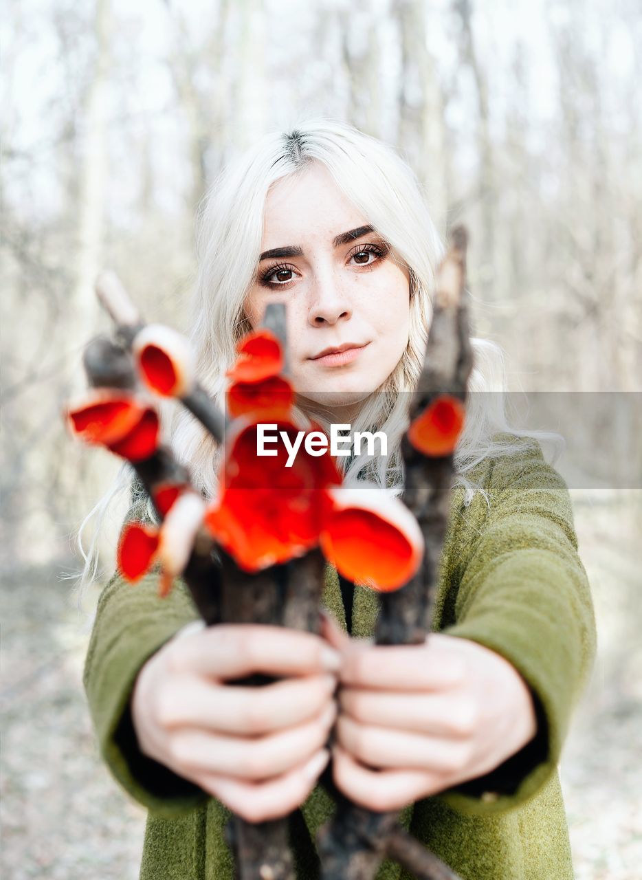 Portrait of young woman holding mushrooms