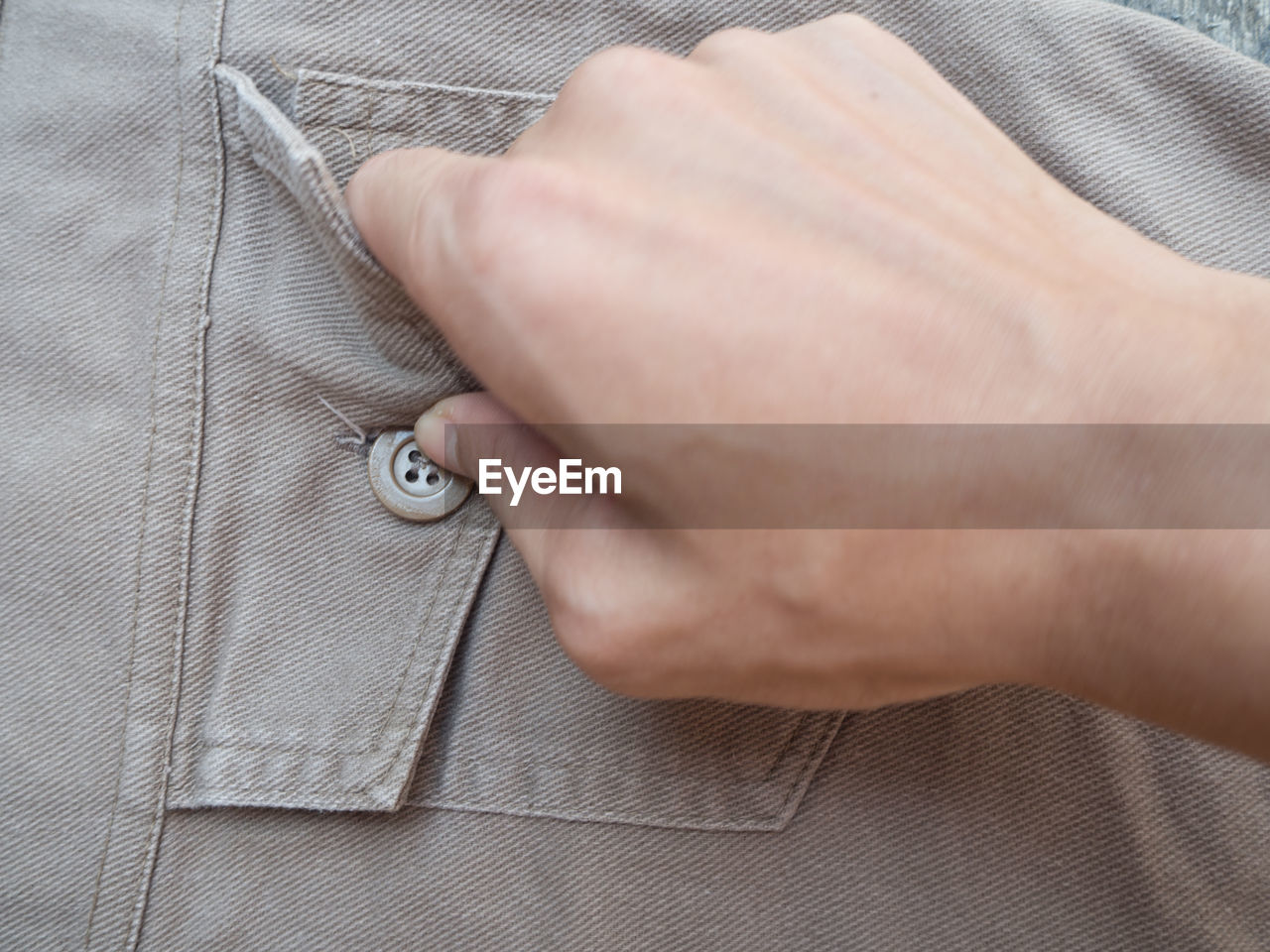 Close-up of man touching button of pocket