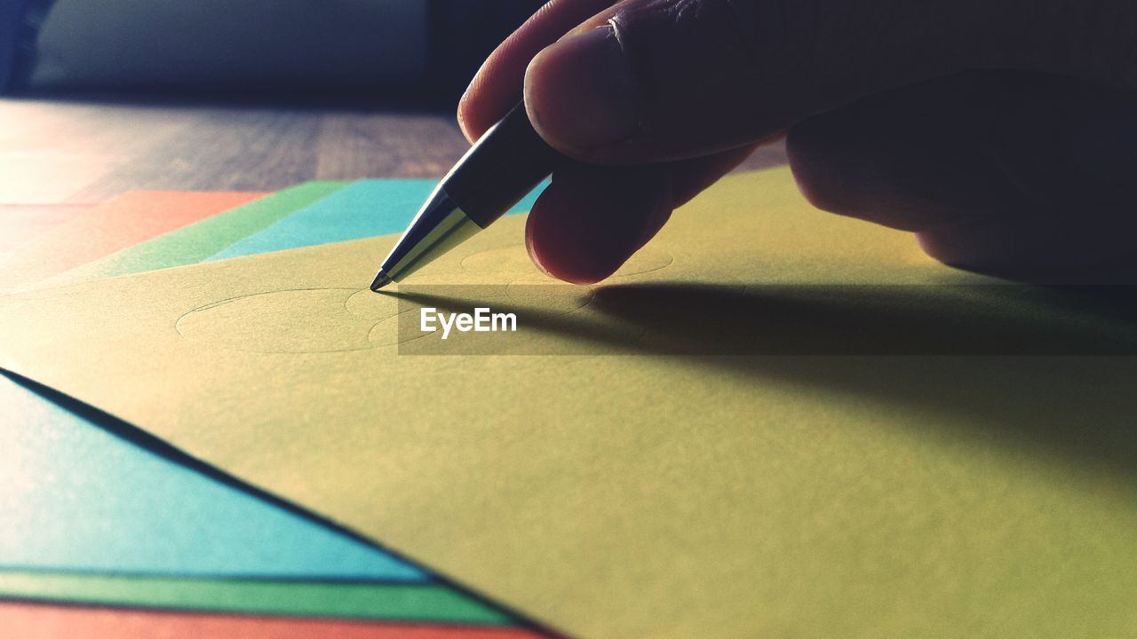 Close-up of hand drawing on yellow paper