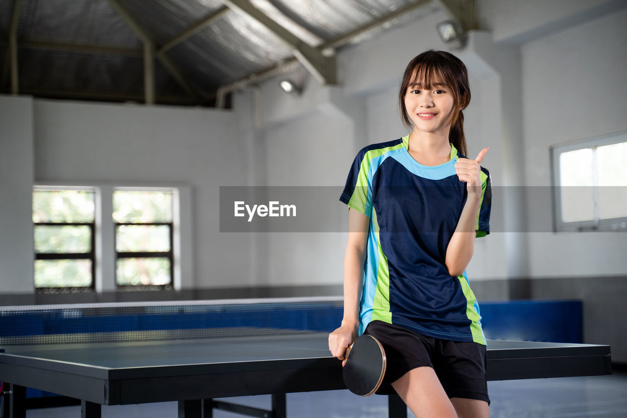 full length of young woman exercising in gym