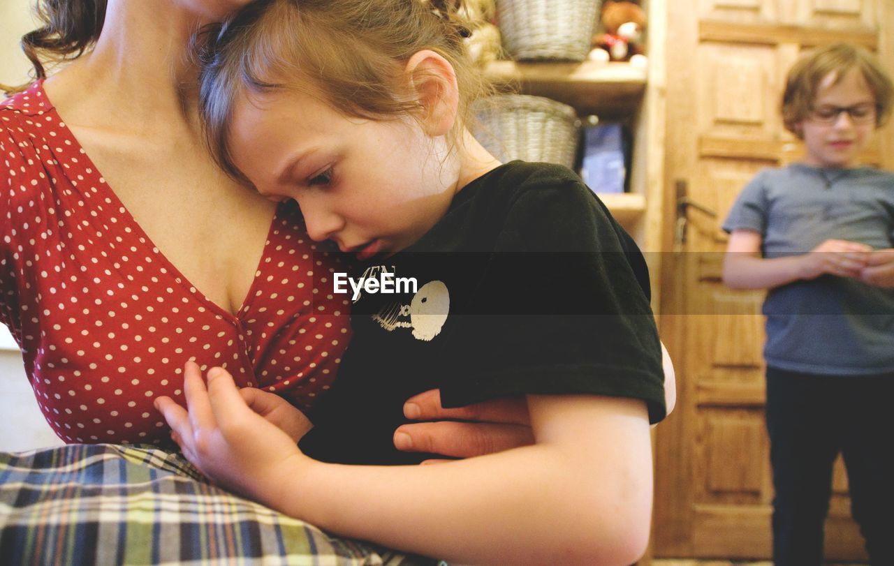 Midsection of mother consoling daughter at home