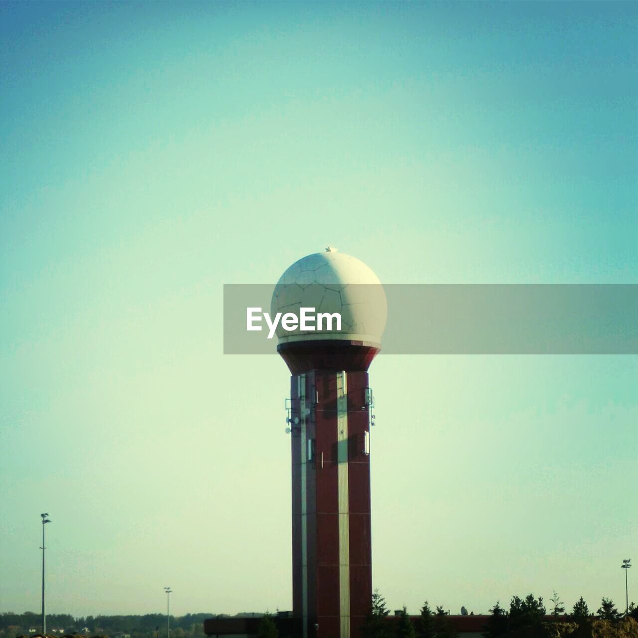 Airport radar tower against clear blue sky