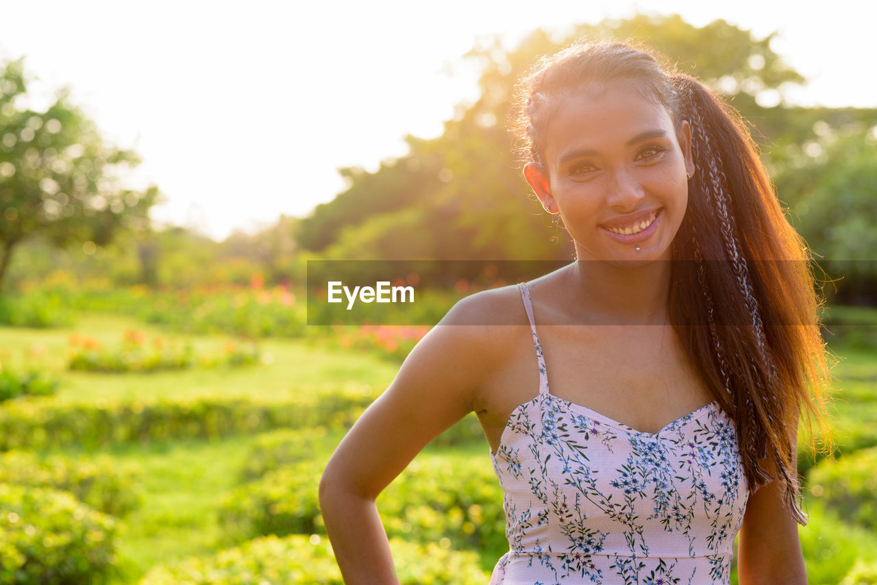 PORTRAIT OF SMILING YOUNG WOMAN