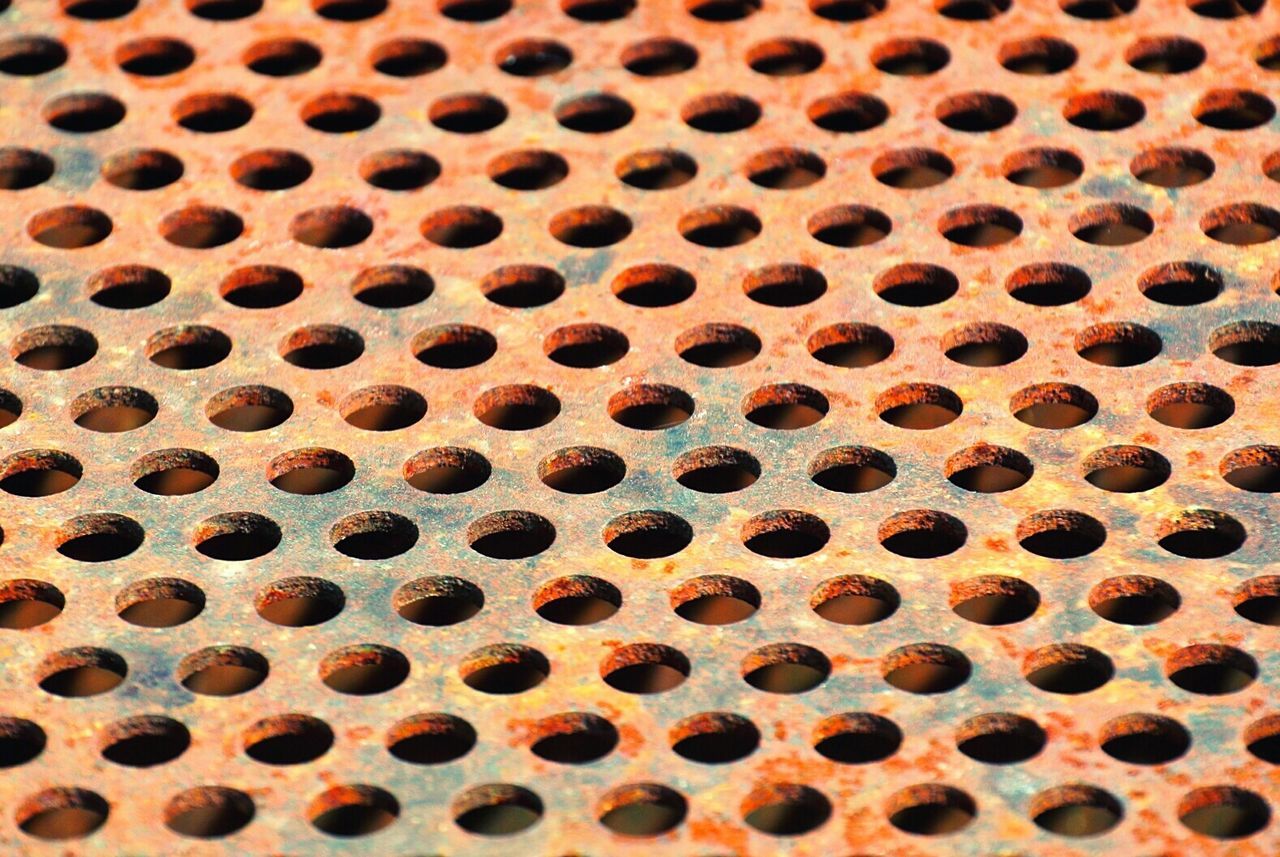 High angle view of rusty perforated metal sheet