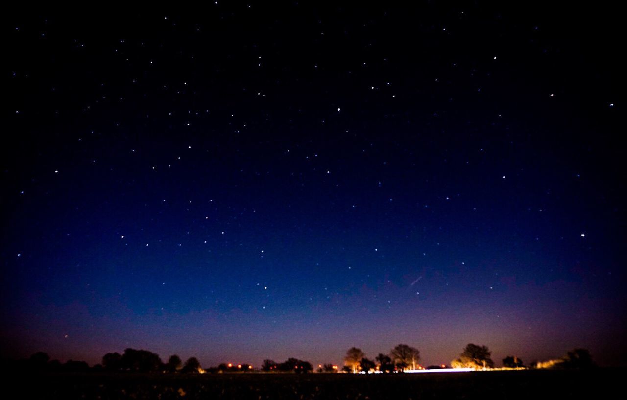 Scenic view of landscape against star field