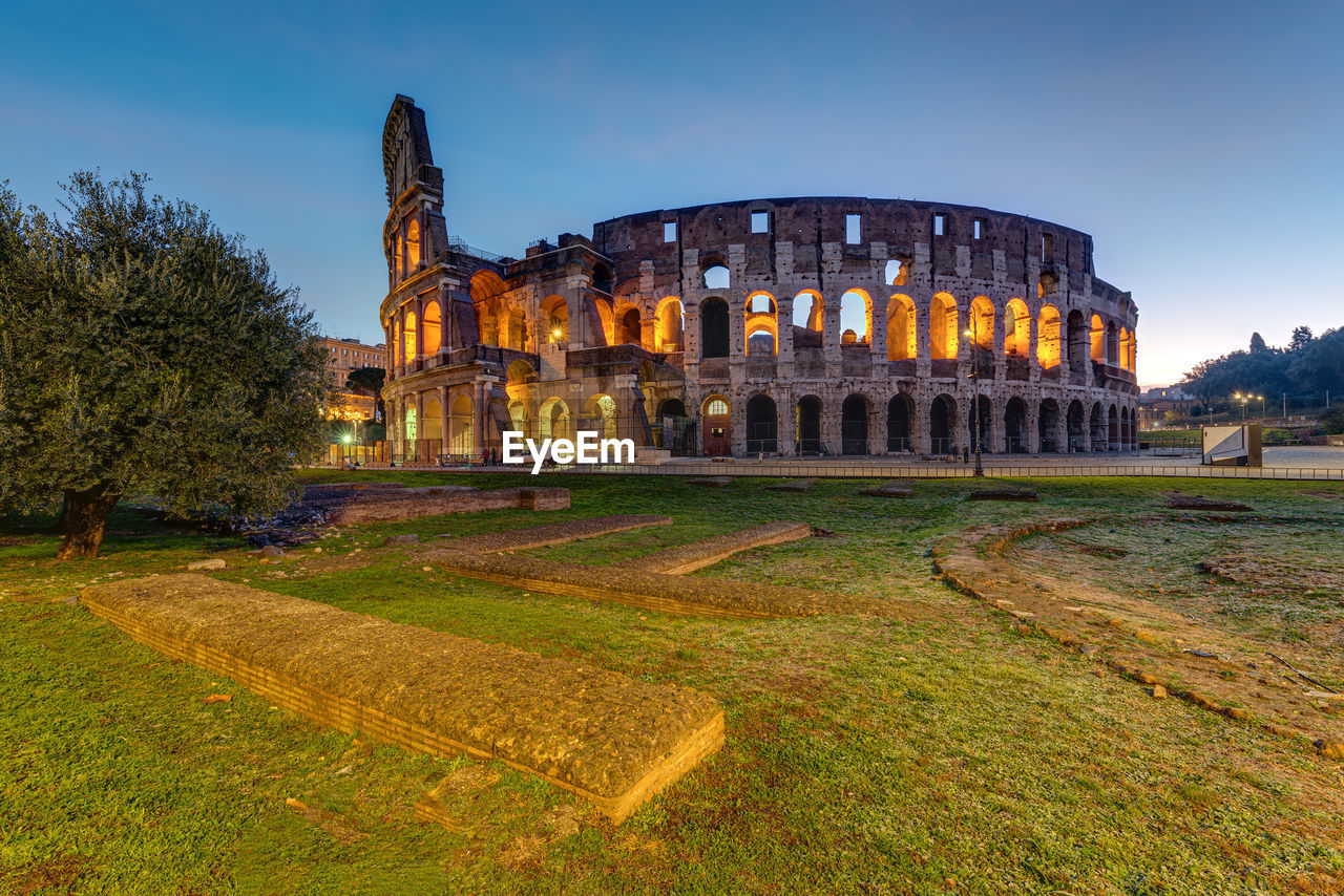 The illuminated colosseum in rome before sunrise