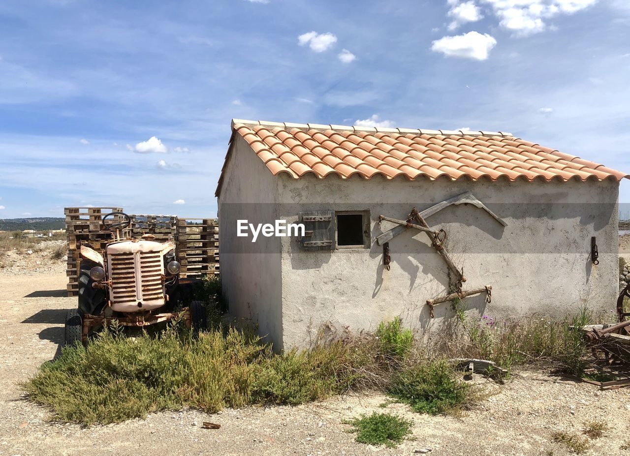 OLD BUILDING ON FIELD AGAINST SKY