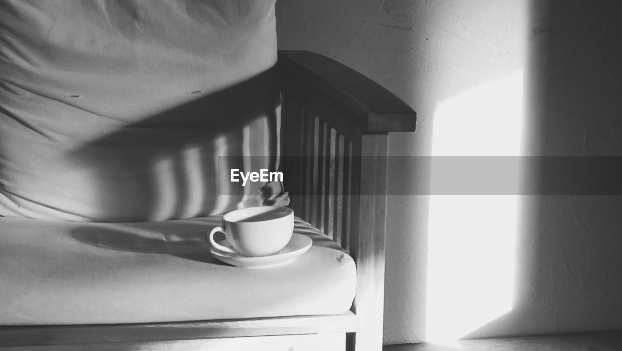 Close-up of coffee cup on sofa at home