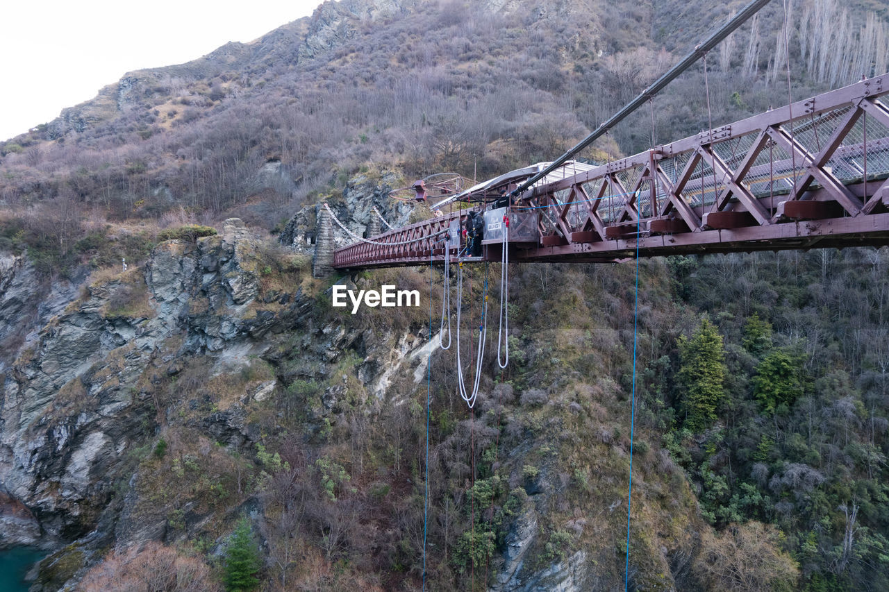 BRIDGE BY MOUNTAINS AGAINST SKY