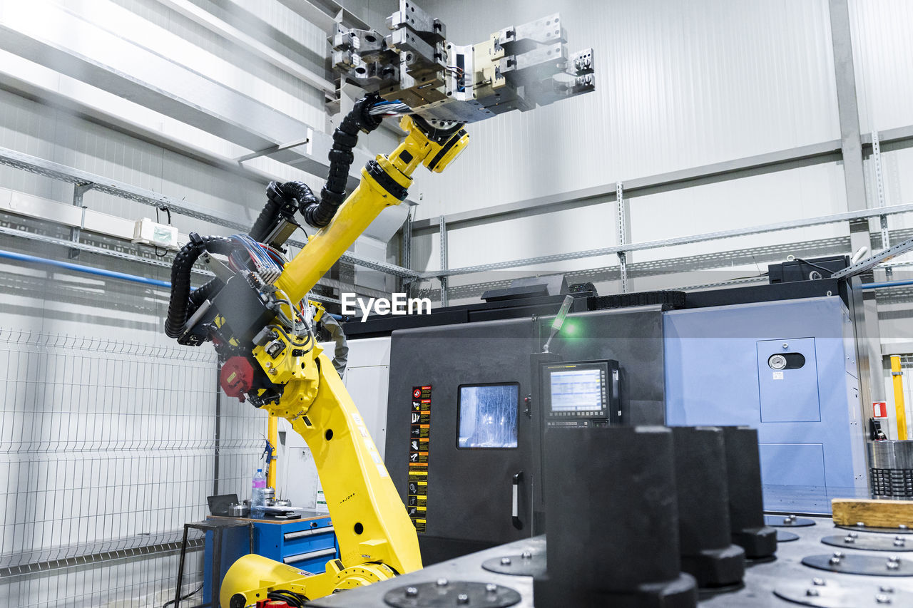 Robotic arm with machinery in factory
