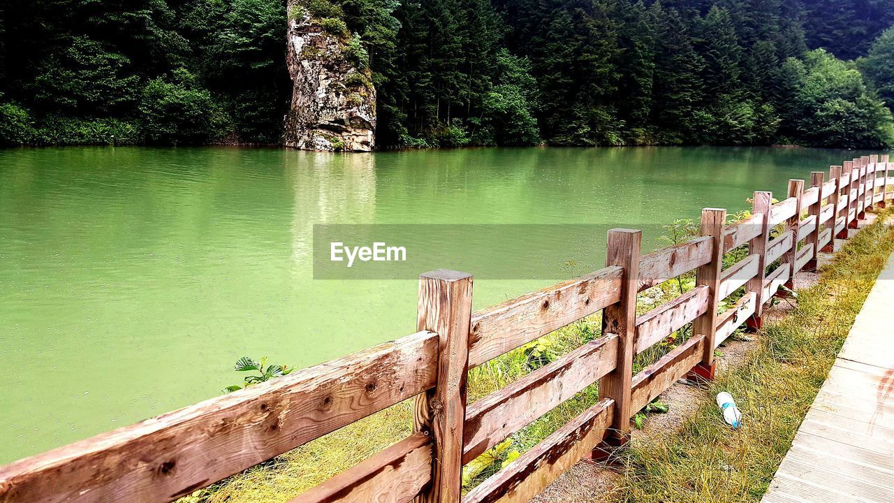 Wooden railing by lake