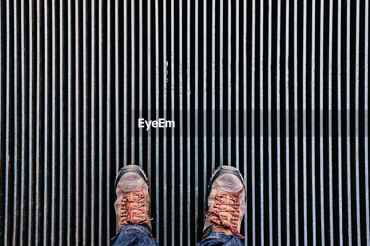 Low section of man standing on metal