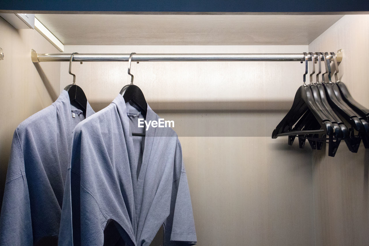 Close-up of clothes hanging on rack in shelf