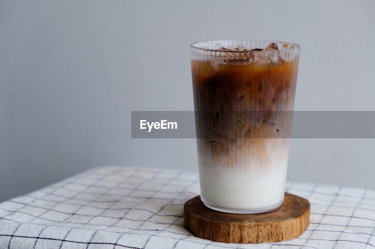 CLOSE-UP OF COFFEE ON TABLE AGAINST GLASS