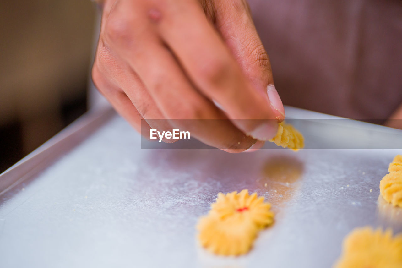 cropped hand of person preparing food on table