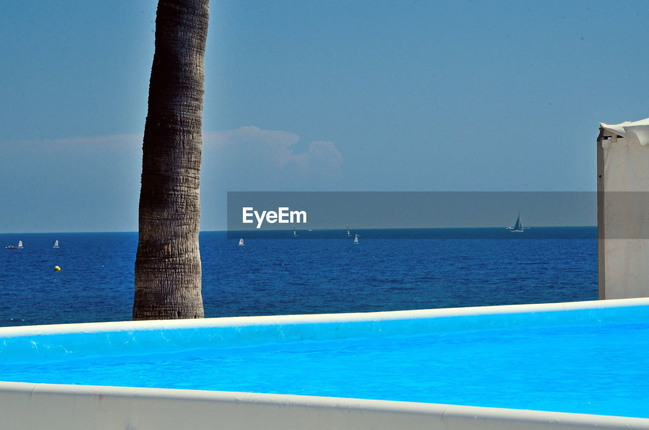 Infinity pool by sea against sky