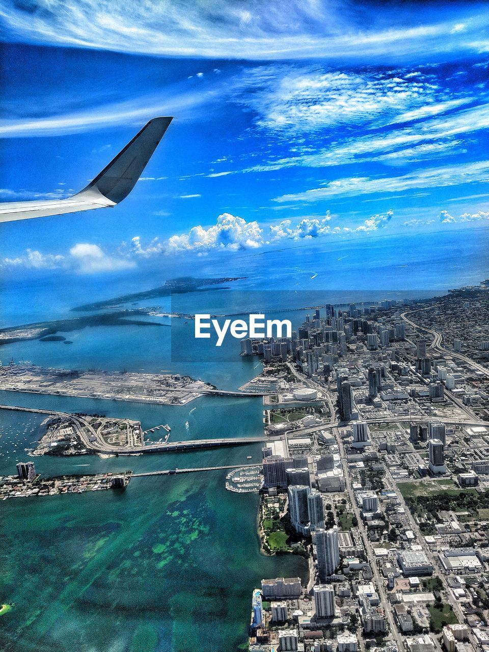 AERIAL VIEW OF CITYSCAPE AND AIRPLANE AGAINST SKY