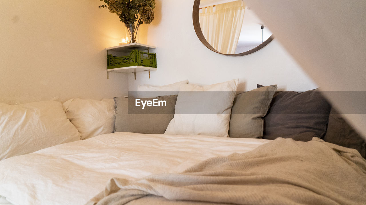 Cushions arranged on bed at home