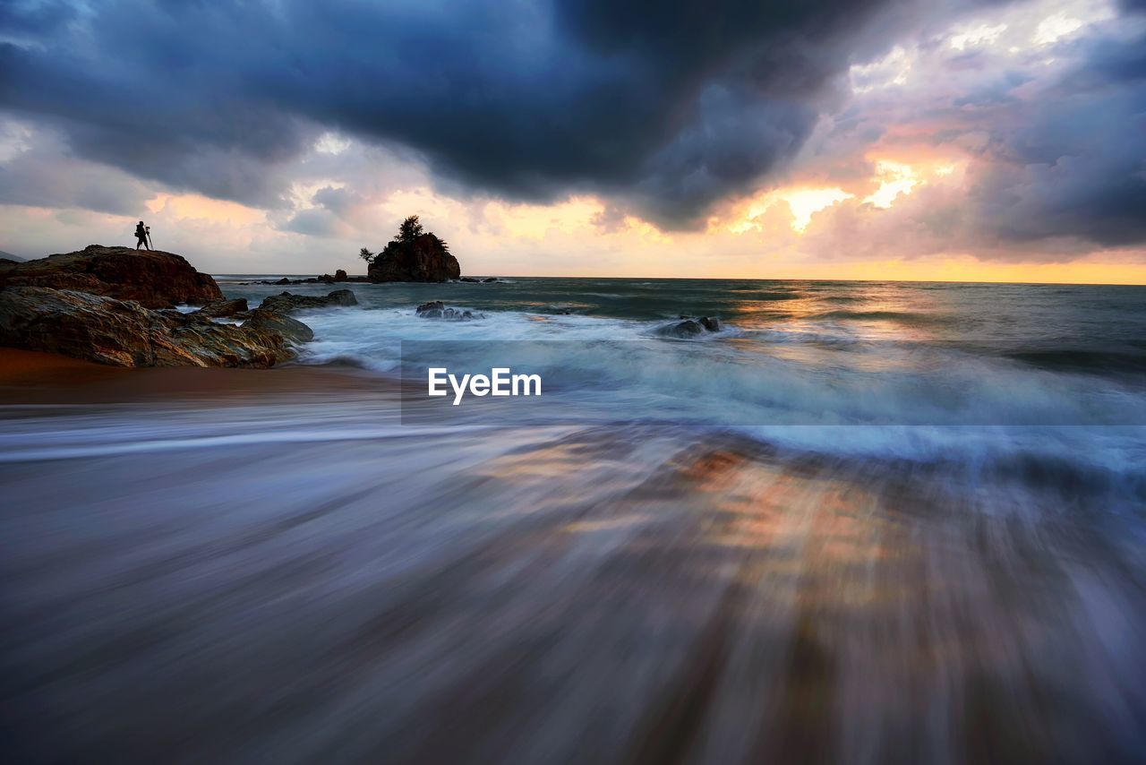 Blurred image of waves at beach during sunset