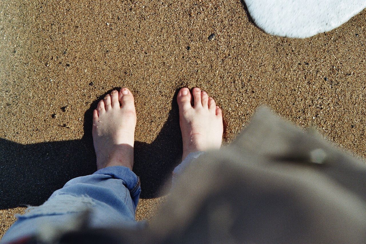 Low section of woman standing at beach