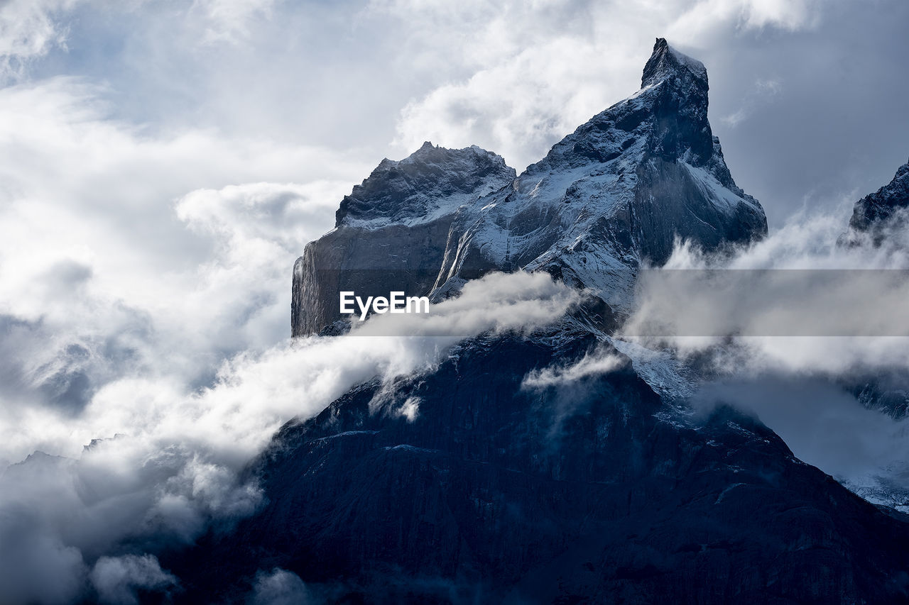 Low angle view of snowcapped mountains against sky