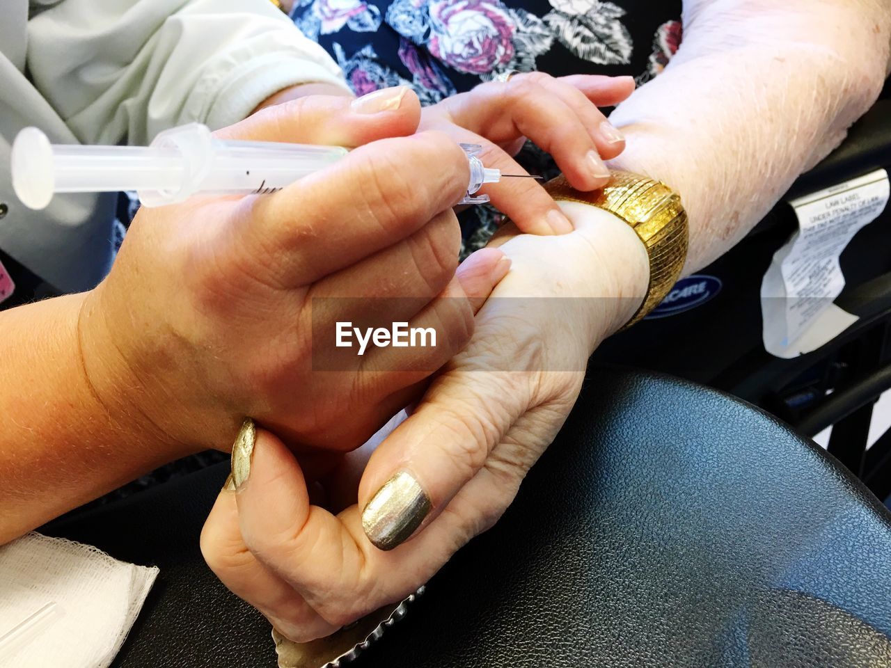 Cropped image of doctor injecting senior female patient
