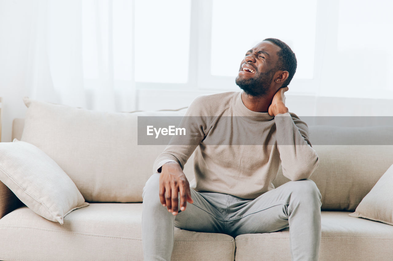 portrait of senior man sitting on sofa at home