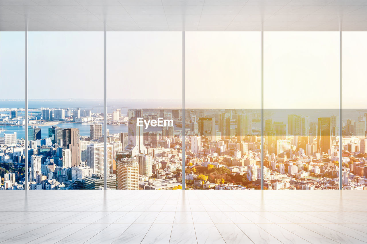 Cityscape seen through glass window during sunset