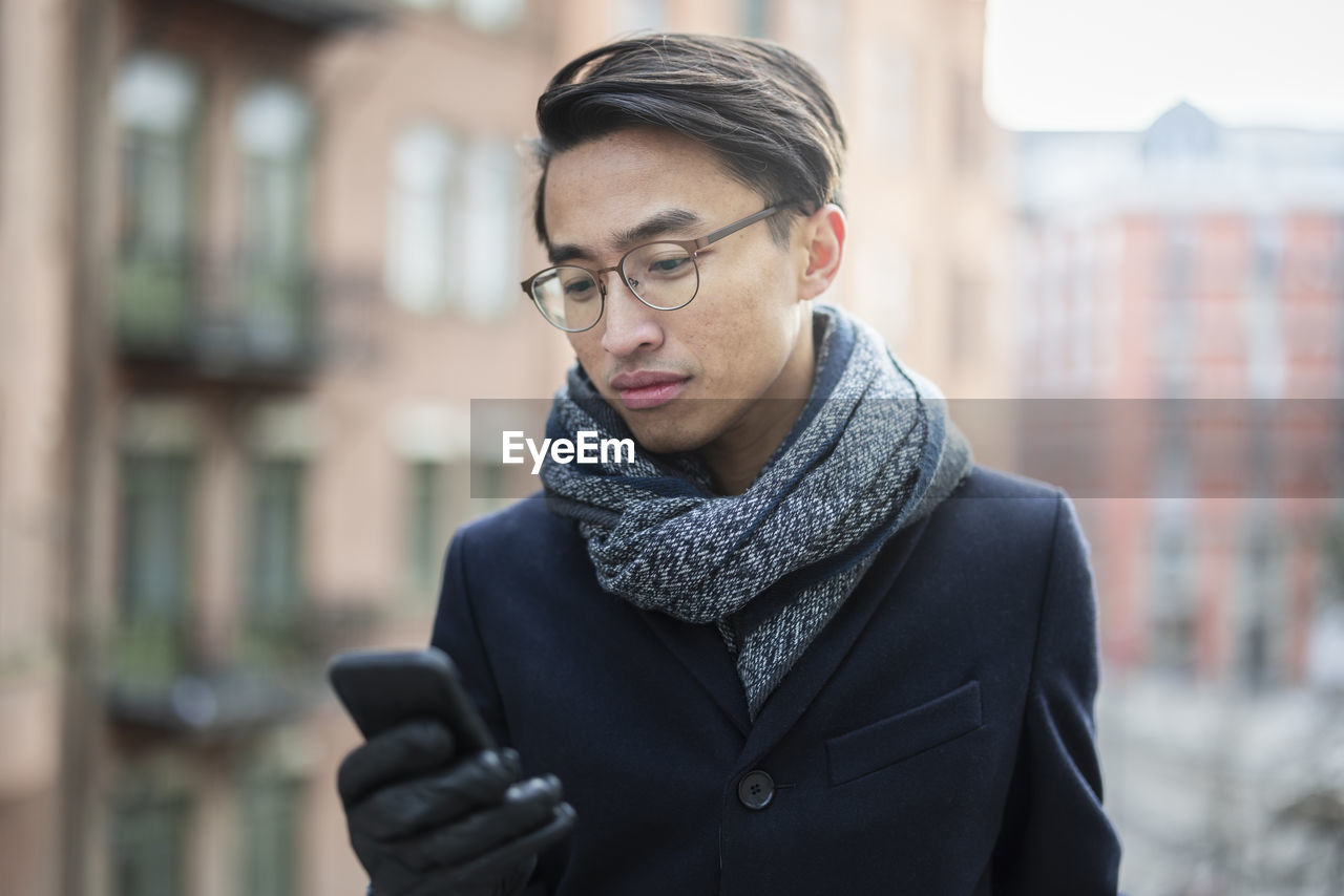 Handsome man with smartphone on street