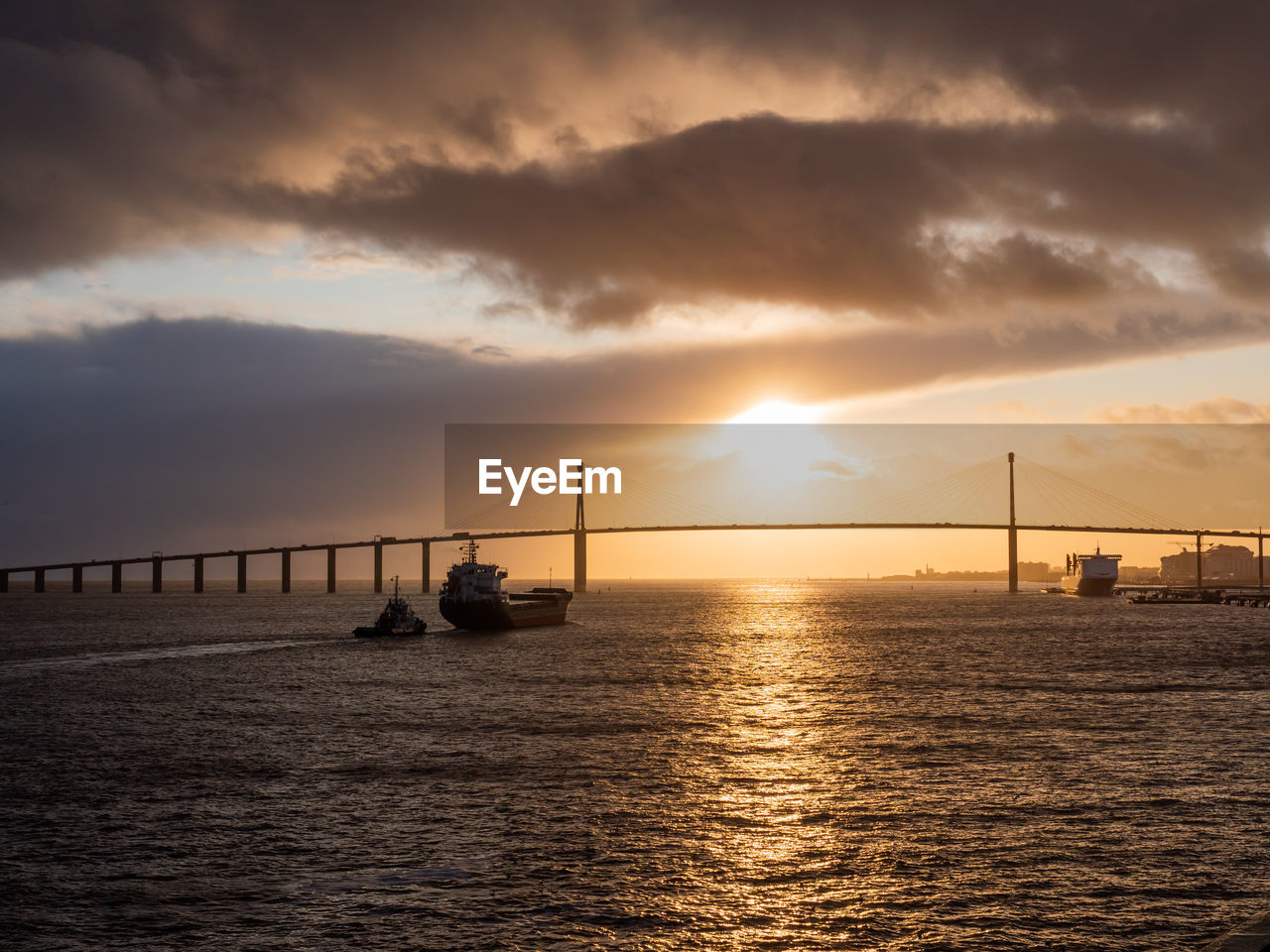 BRIDGE OVER SEA AGAINST SKY DURING SUNSET