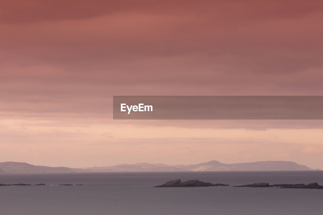 Scenic view of sea and mountains against sky