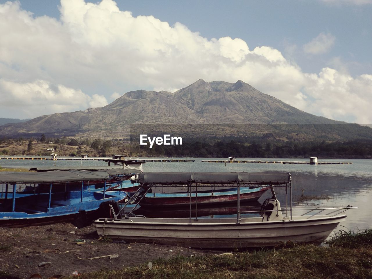 Boats in sea against cloudy sky