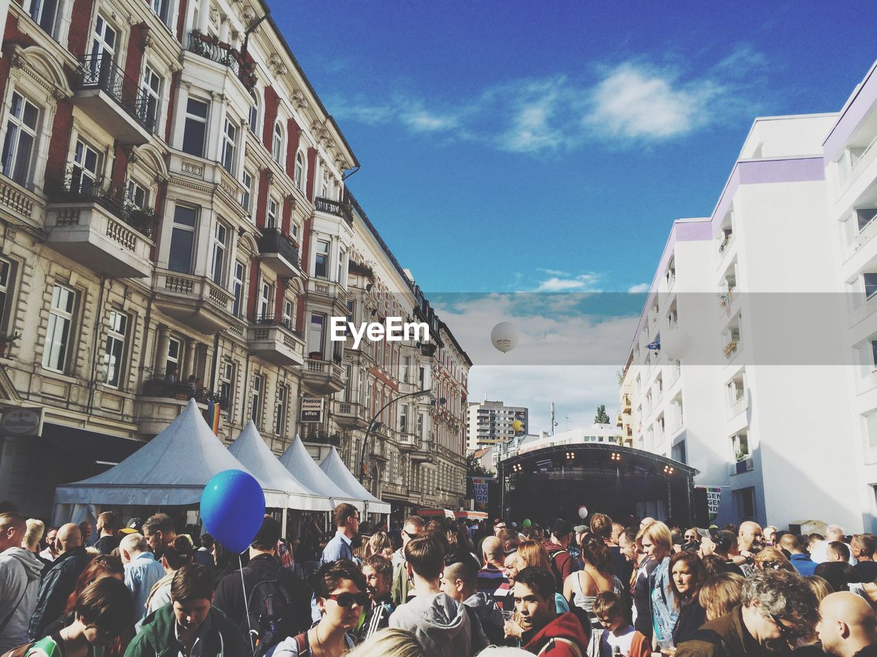 People on street amidst buildings during festival