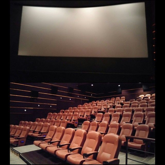 arts culture and entertainment, chair, in a row, indoors, auditorium, audience, seat, large group of objects, projection equipment, film industry, day