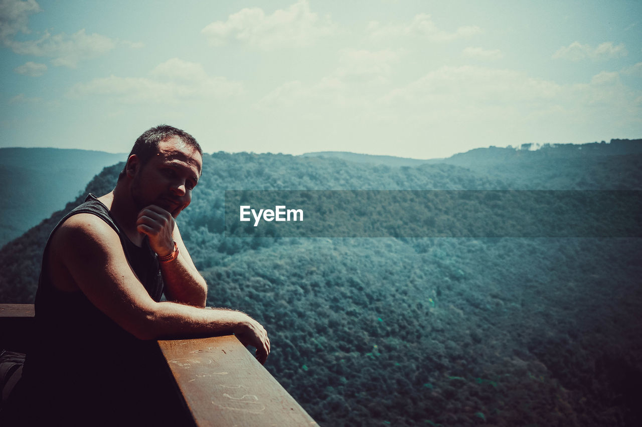 Man standing at observation point against mountain range