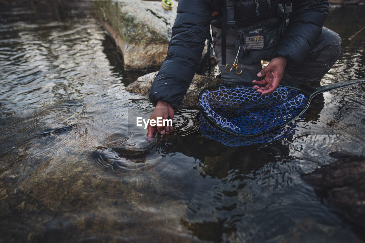 A man released a brook trout during a cold morning fishing in maine