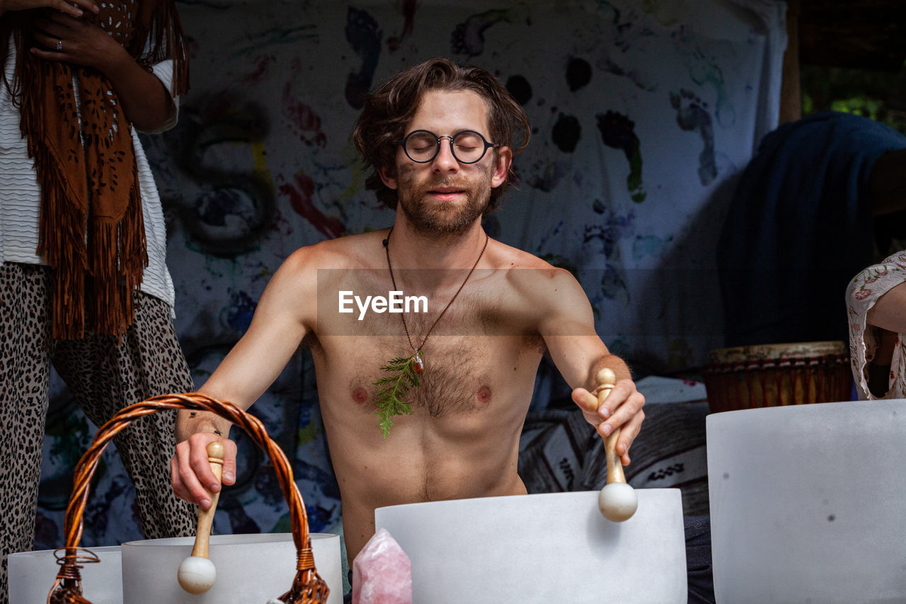 Portrait of shirtless man standing on table