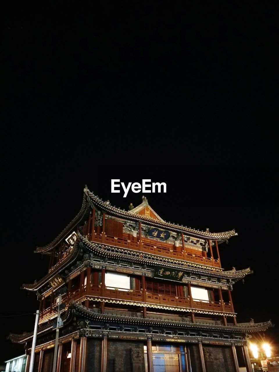 LOW ANGLE VIEW OF ILLUMINATED TEMPLE AGAINST SKY