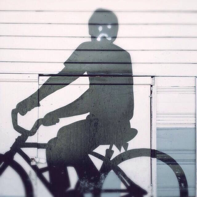 Shadow man riding bicycle on wall