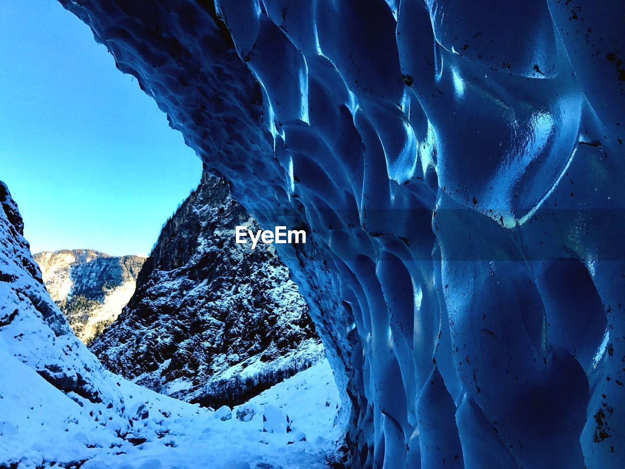 Snow covered mountain against blue sky