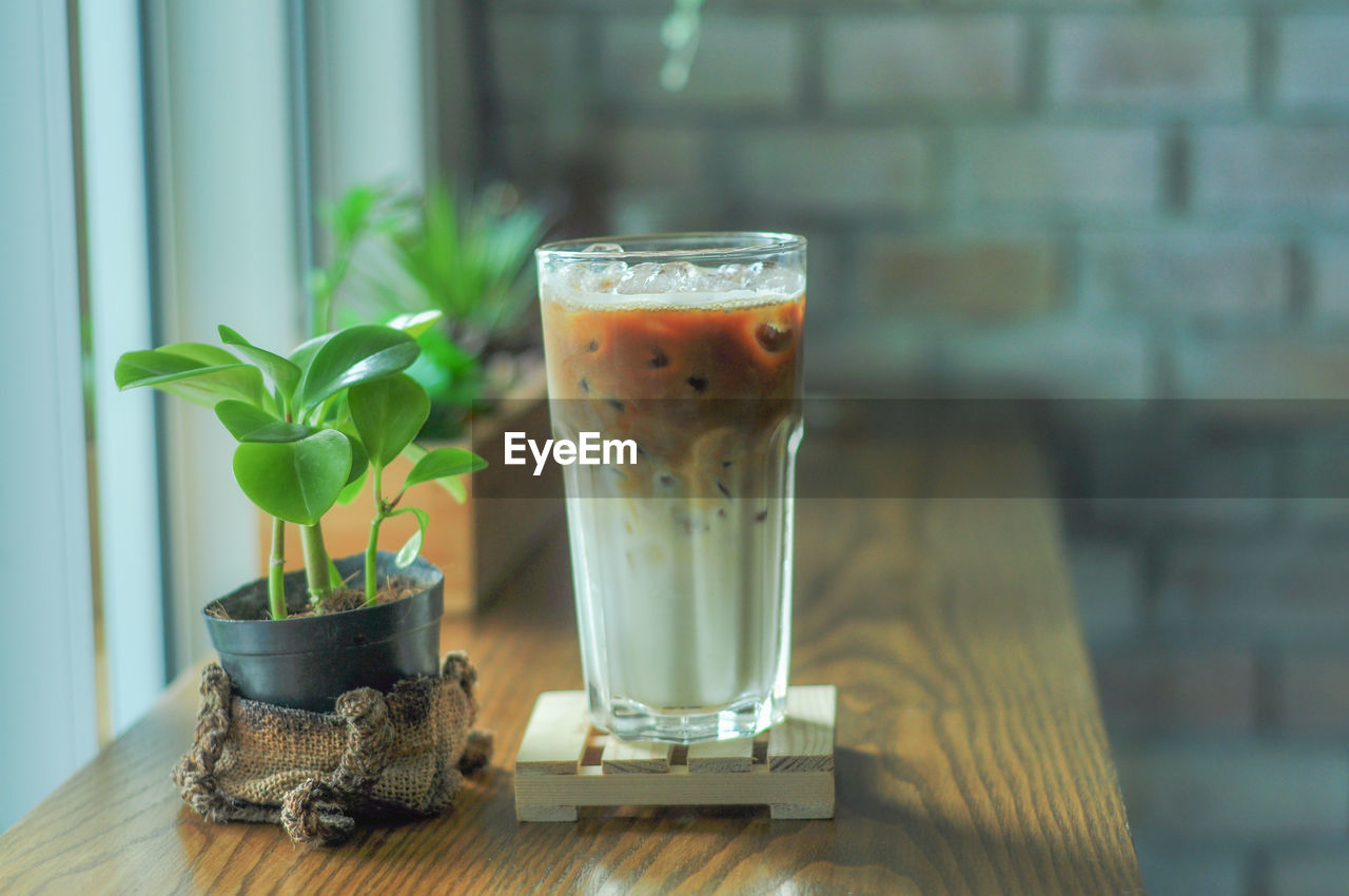 CLOSE-UP OF DRINK ON GLASS TABLE