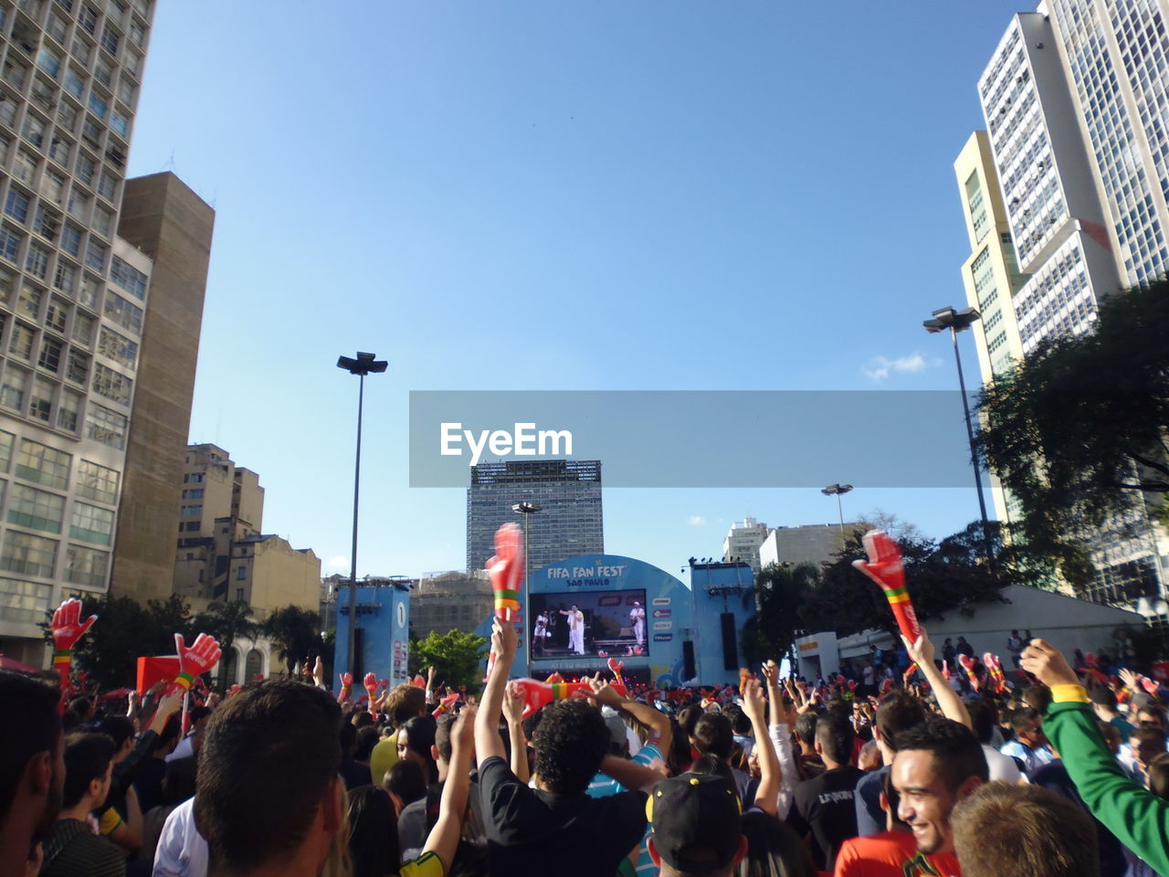 CROWD ON CITY STREET AGAINST SKY