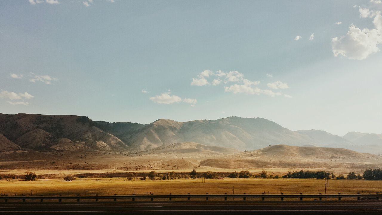 Scenic view of field and mountains against sky