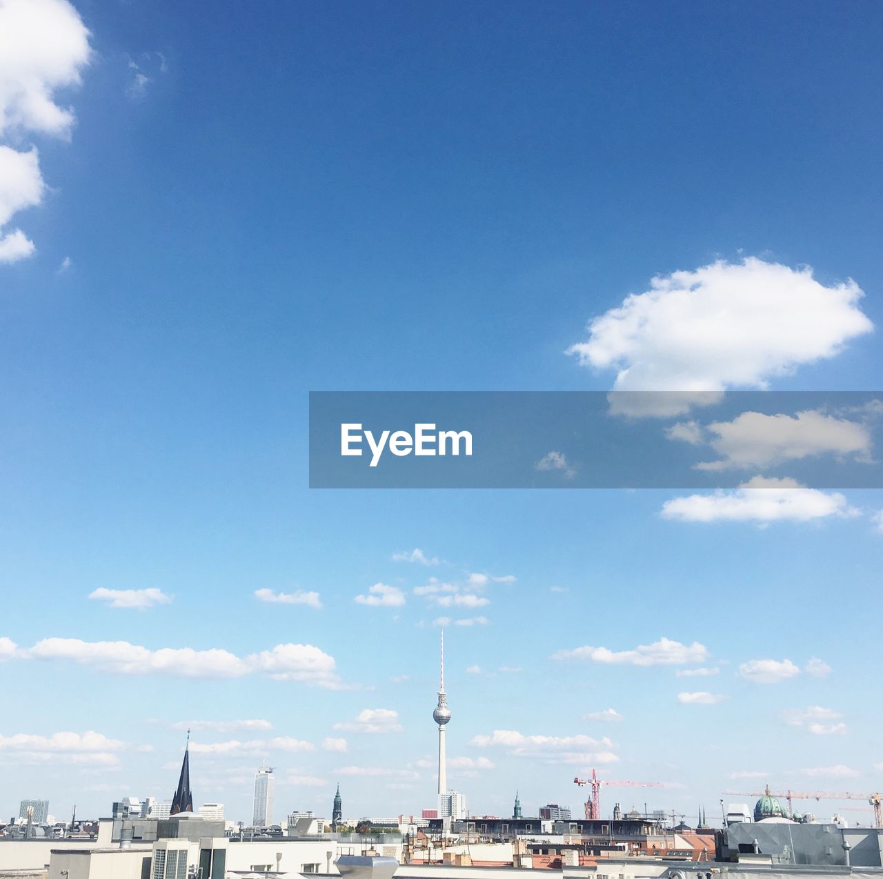 Distant view of fernsehturm in city against sky