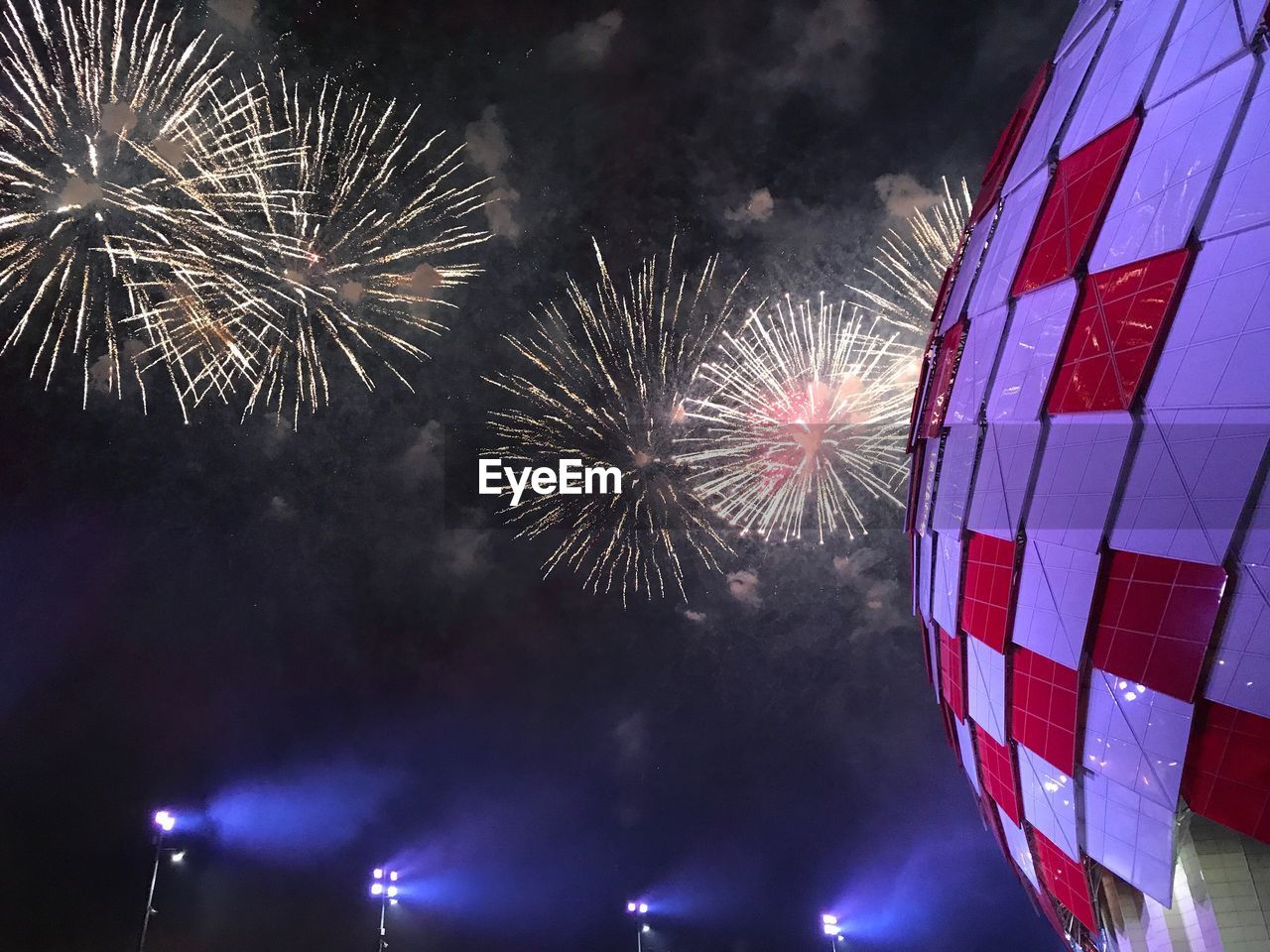 LOW ANGLE VIEW OF ILLUMINATED FIREWORK DISPLAY AT NIGHT